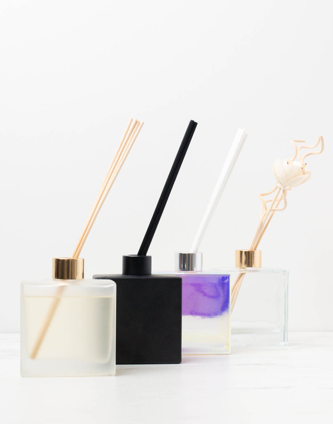 A line of reed diffusers showing the different types of finishes and reeds available. 